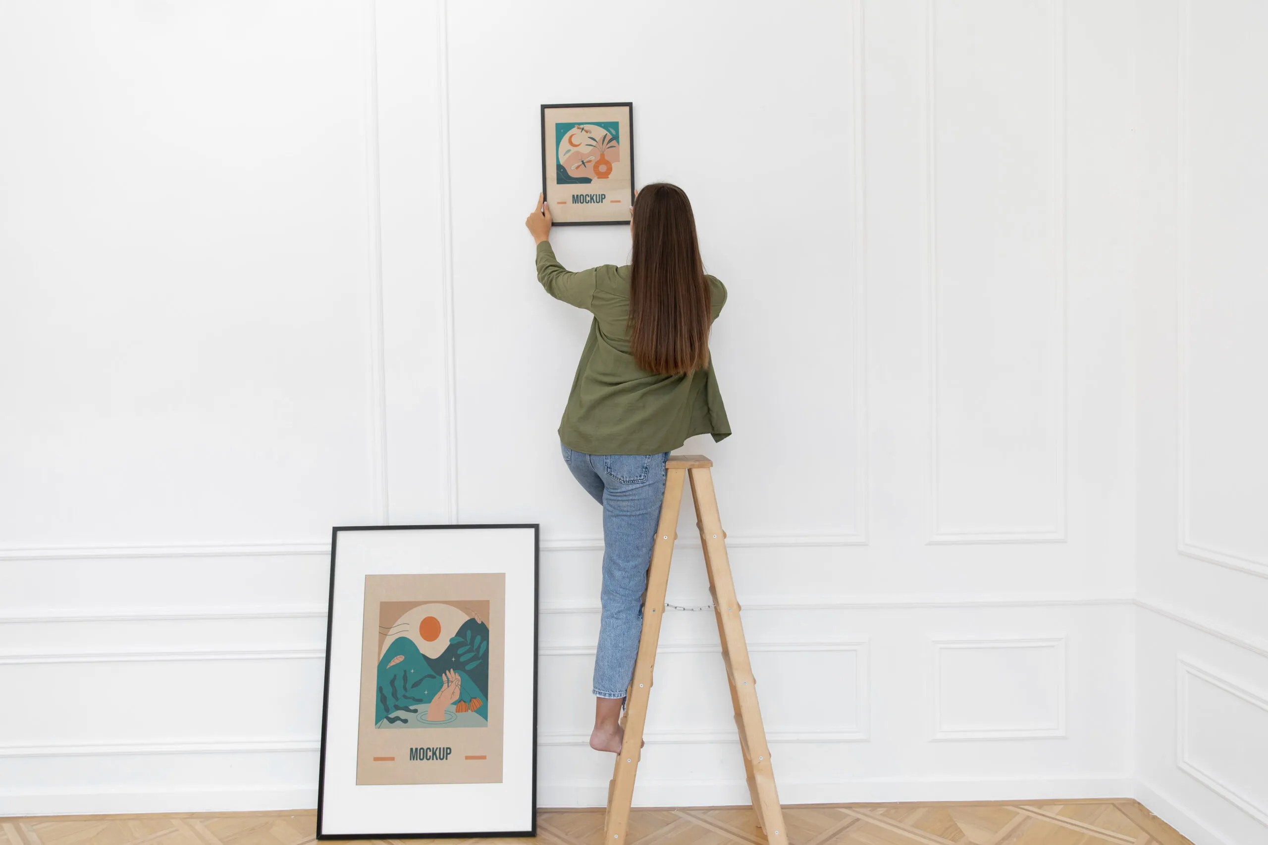 Woman decorating a wall with wall-art.