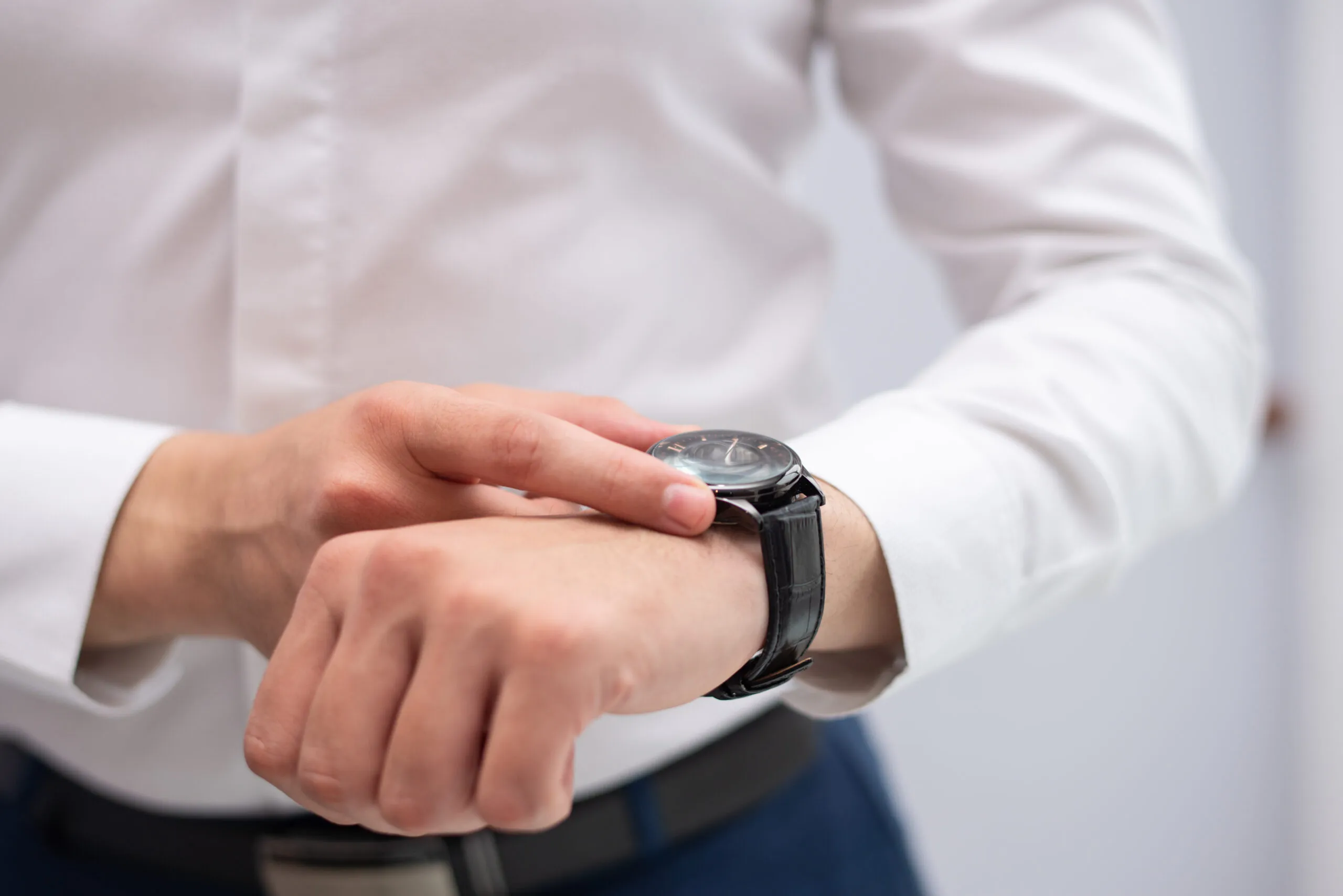Close-up of businessman looking at his modern wristwatch.