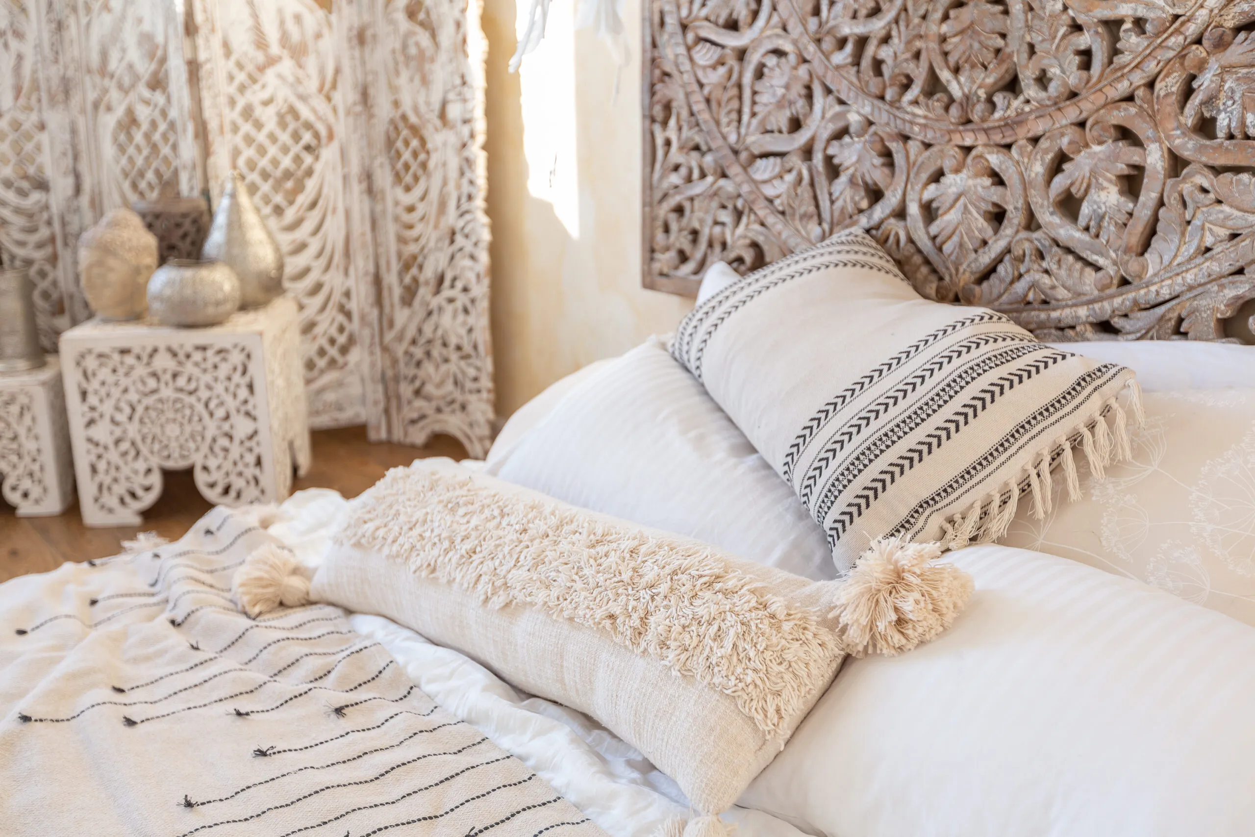 white walls, wood floors, pillows and vintage furniture.
