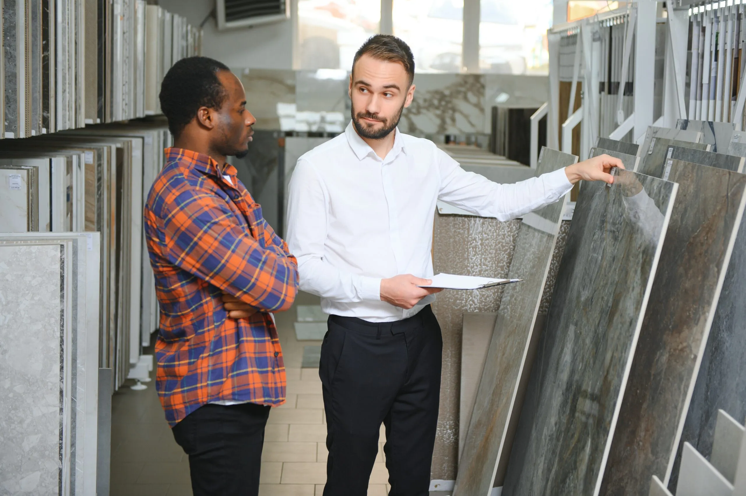 Young African man choosing tiles at building market.