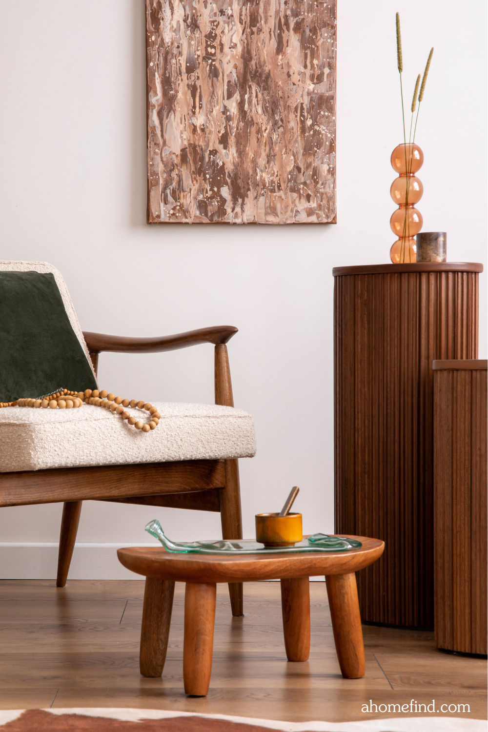 A mid century modern living room with a dark wooden stool and wooden piedestals. 