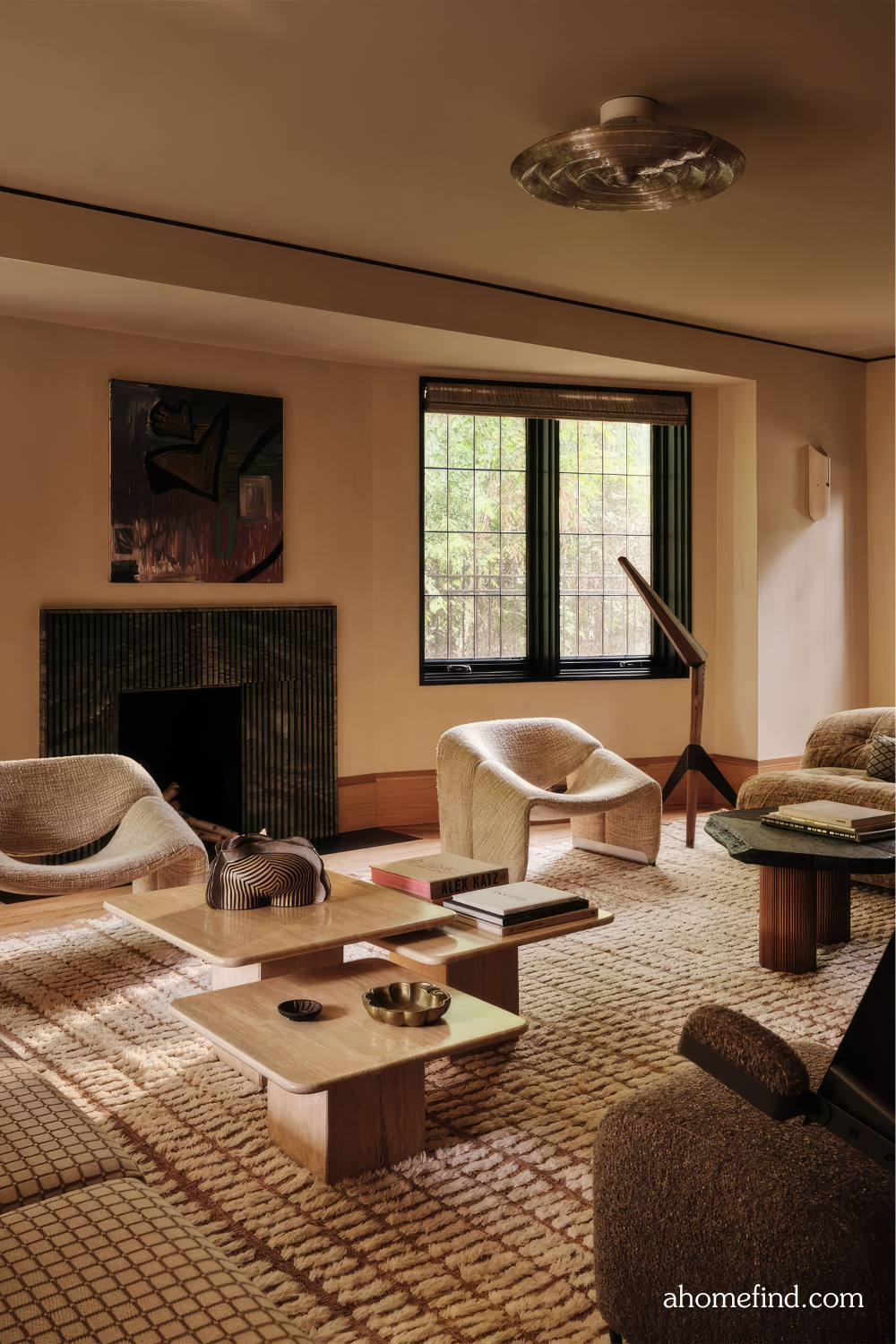 A beautiful mid century modern living room with wooden details, white armchairs and a large rug. 