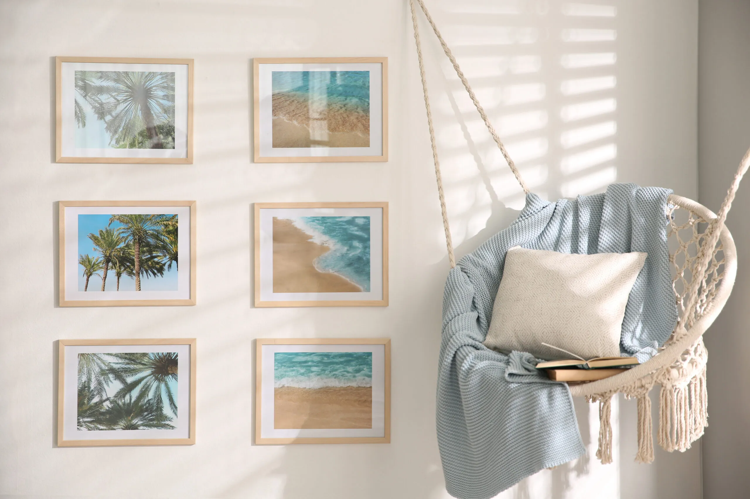 Different pictures on wall and hanging chair in room.