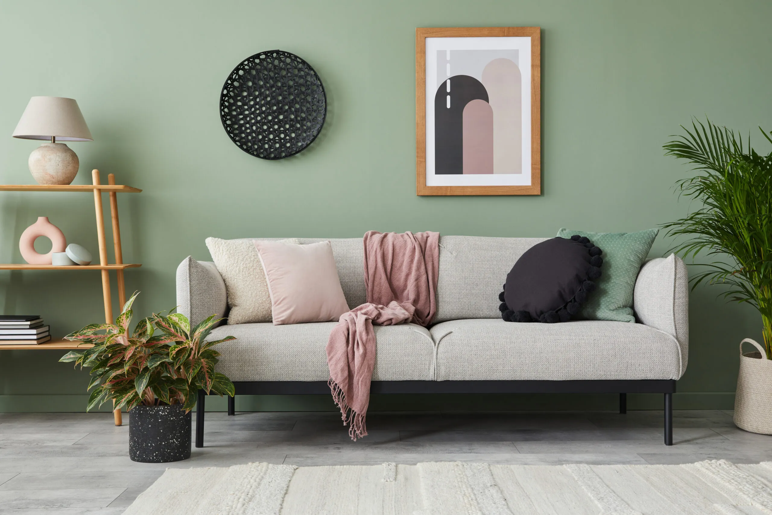 Modern living room with green walls and a gray couch.