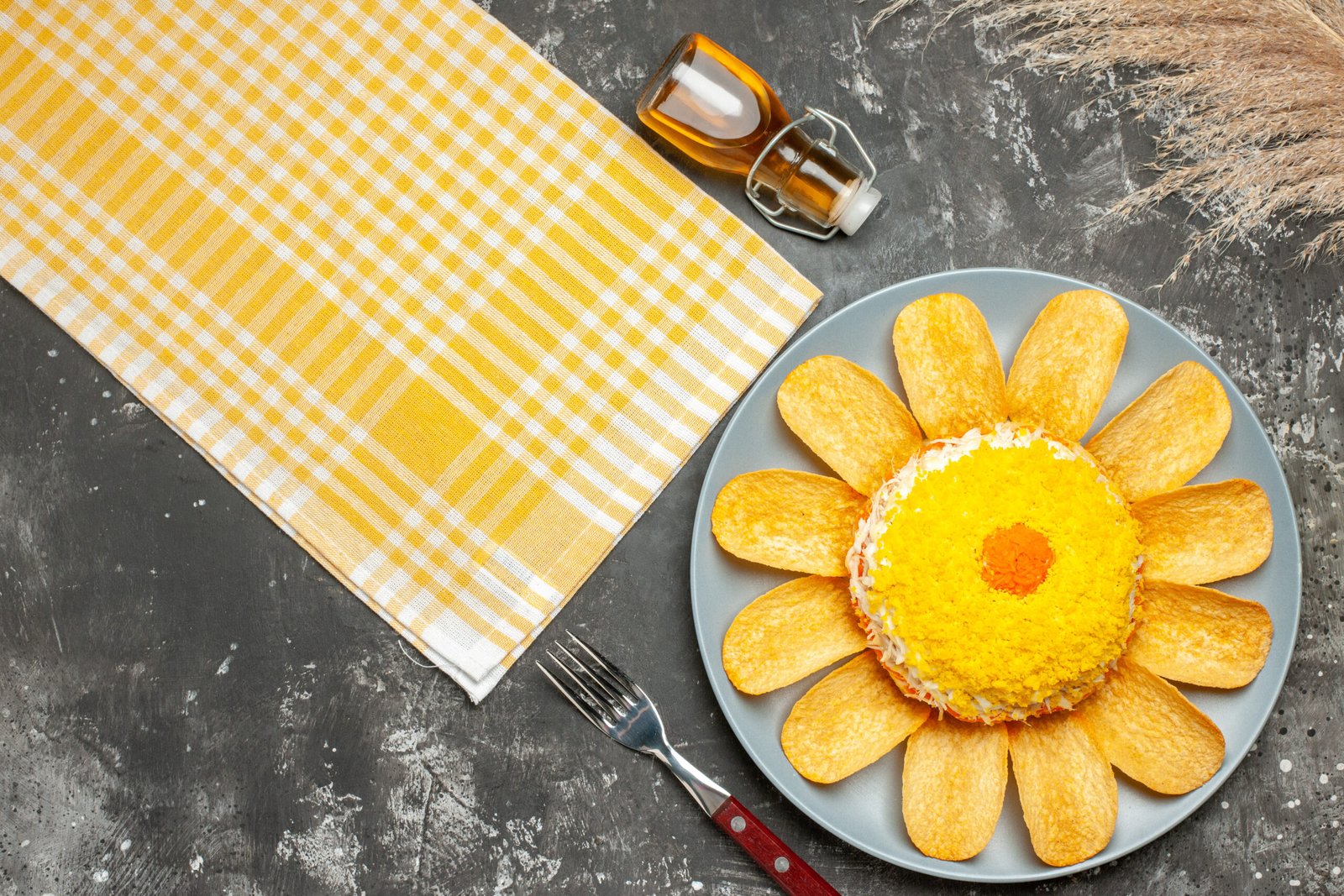 Yellow kitchen towel beside a plate with a yellow flower on it.