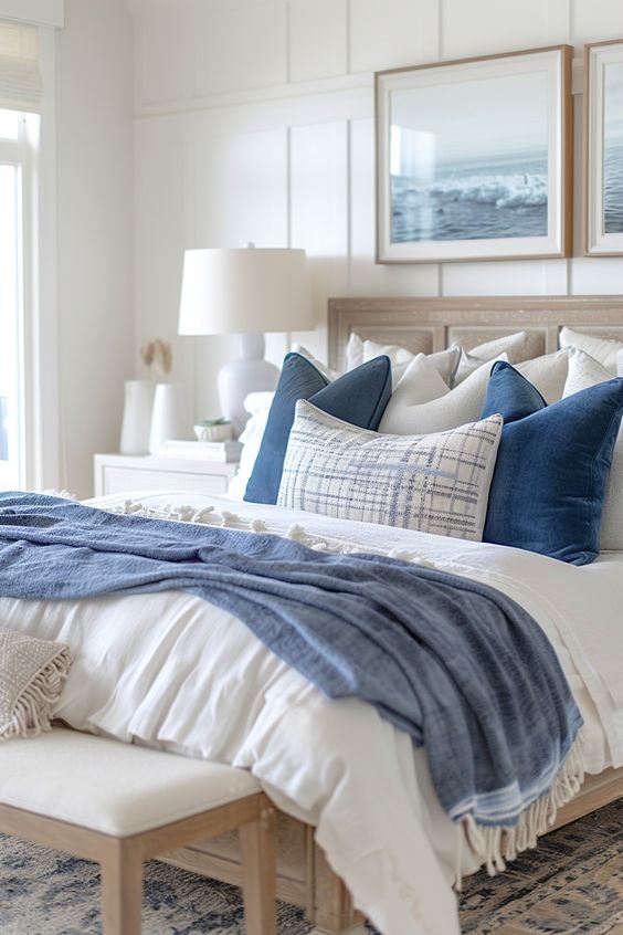 Modern coastal bedroom with a large bed and lots of pillows.