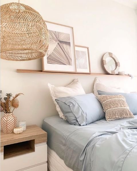 Coastal bedroom vibe with a wooden shelf.