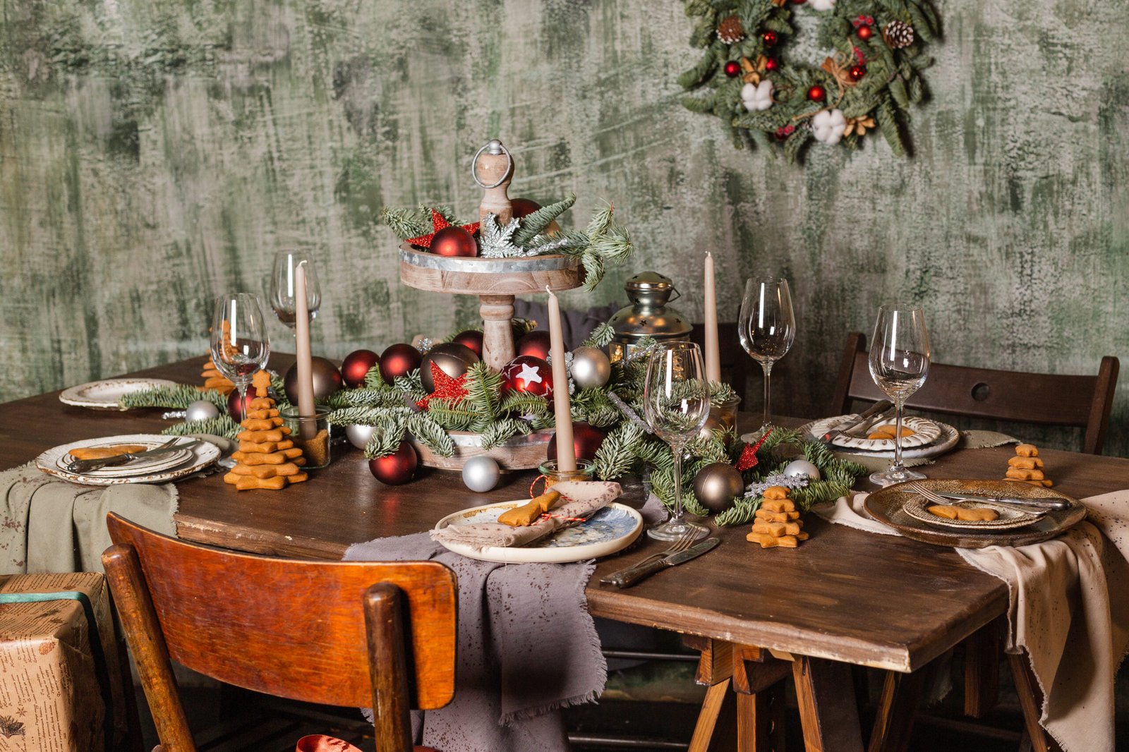 The table is set with food and decorated in New Year's style. Fir twigs, Christmas decorations, lighted candles. 