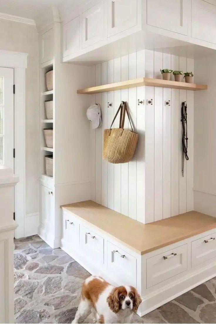 Functional mud room in white colors with wooden details. 