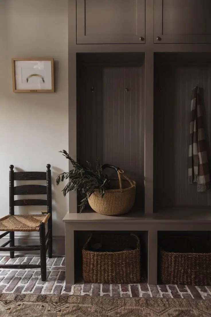 Brown cottage mud room with a chair and a plant. 