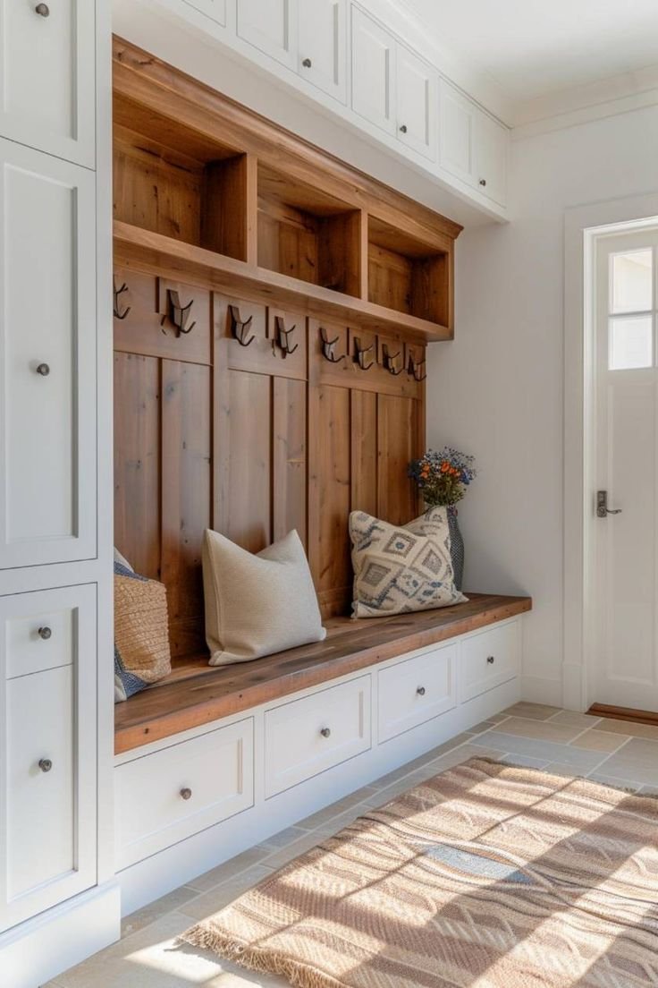 Mud room with wooden details, cozy pillows and white base. 