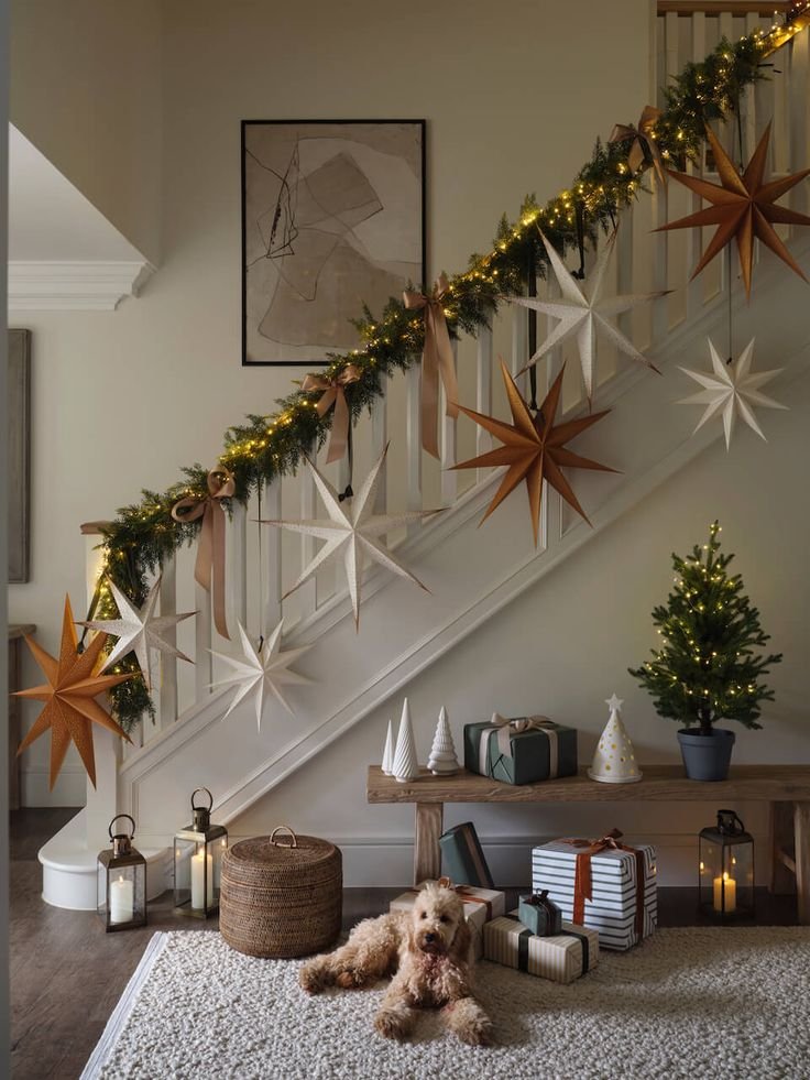 Christmas decorated hallway with a garland and hanging stars on the stair. 