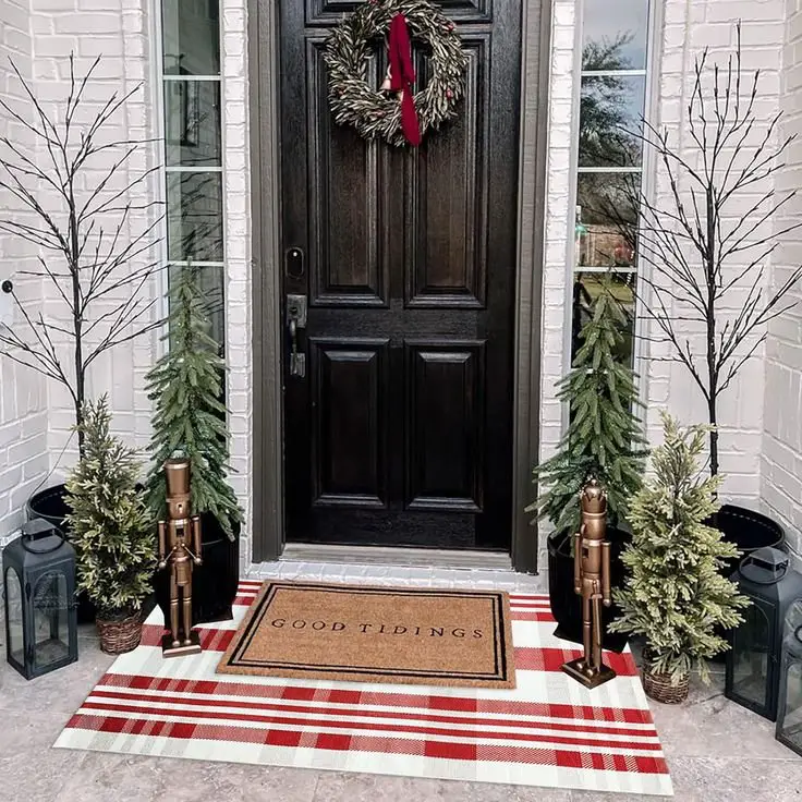 Christmas porch with a plaid rug and a Christmas rug. 
