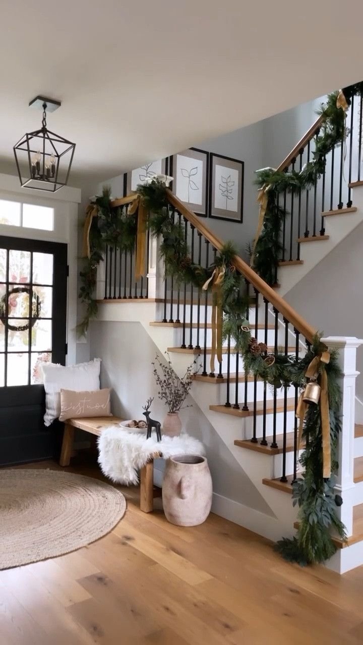 Hallway decorated with a garland on the stairs and a cozy seating area. 