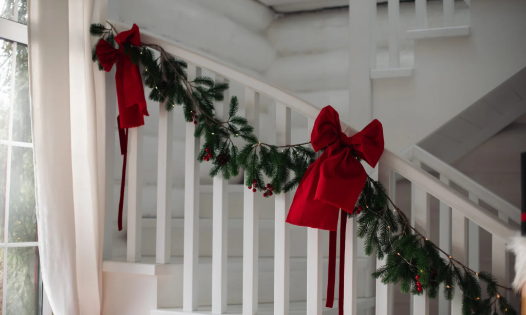 Christmas Hallway Decorating Ideas with red bows and a garland.