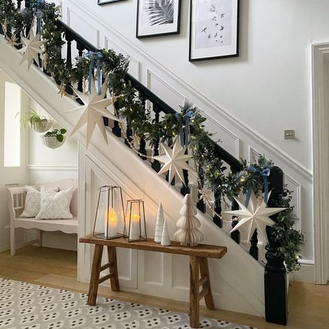 Stairs decorated with white stars and a green garland. 