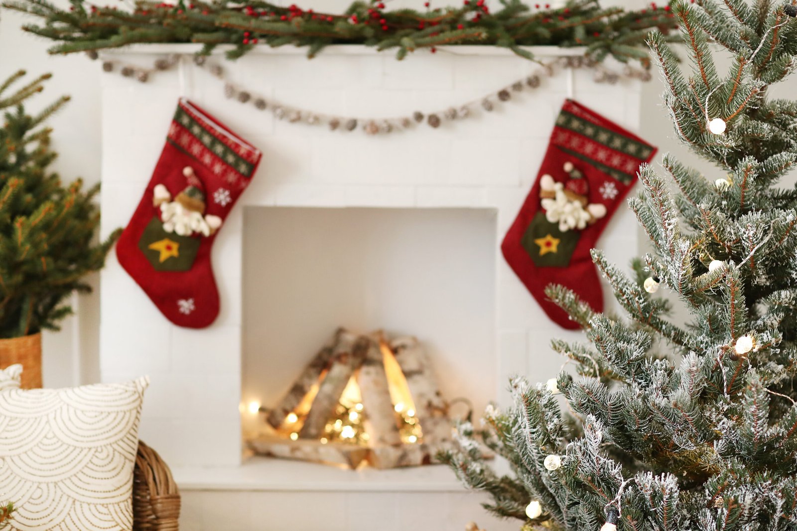 Christmas decorated mantle with stockings and a christmas tree. 