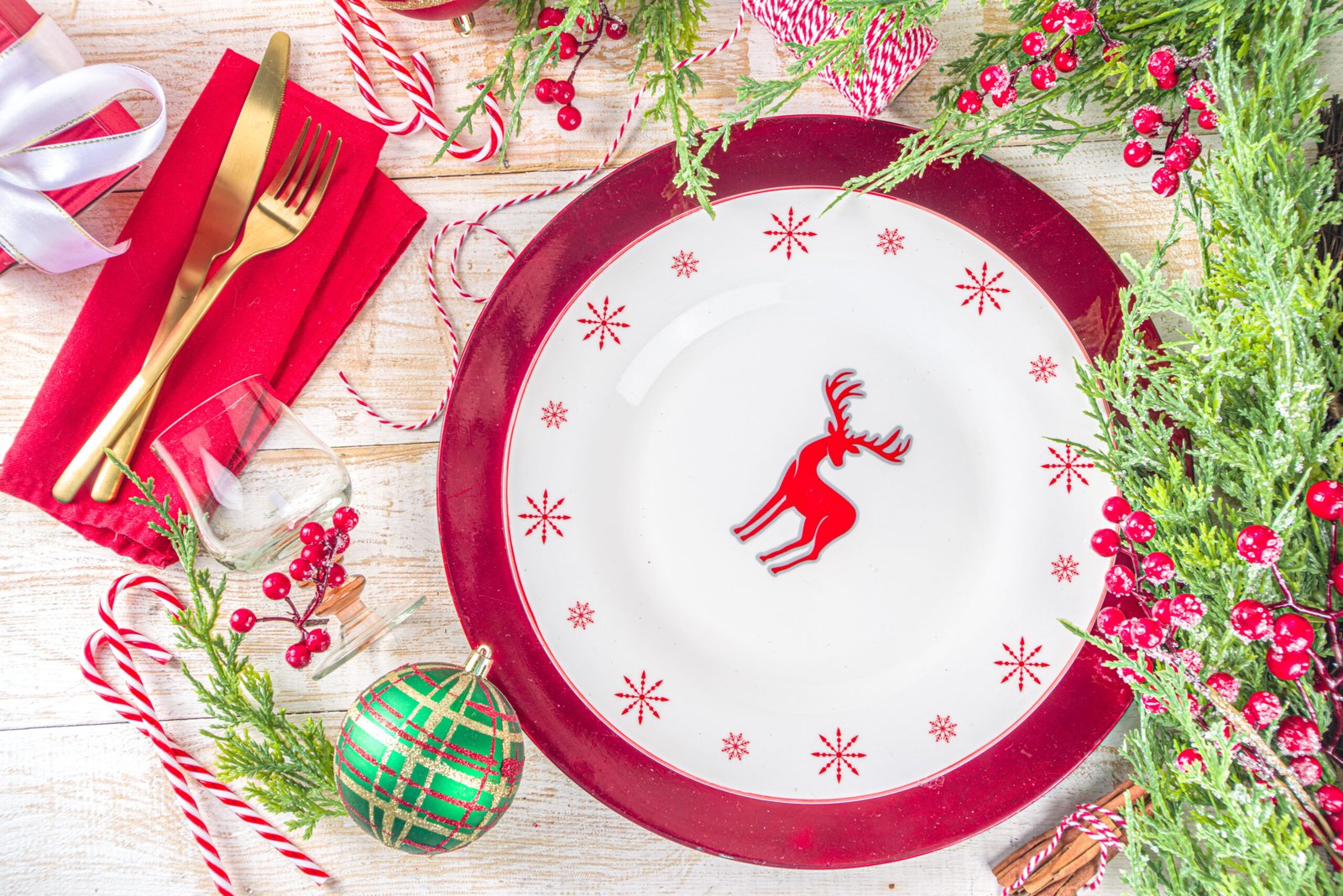 Christmas table setting. Place setting for Christmas Dinner. On wooden background with Holiday Decorations