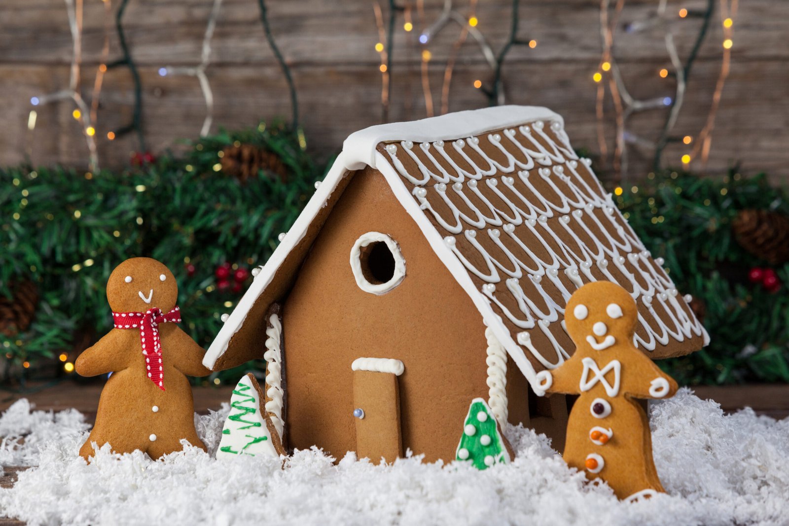 Gingerbread house and cookies arranged together during christmas time. 