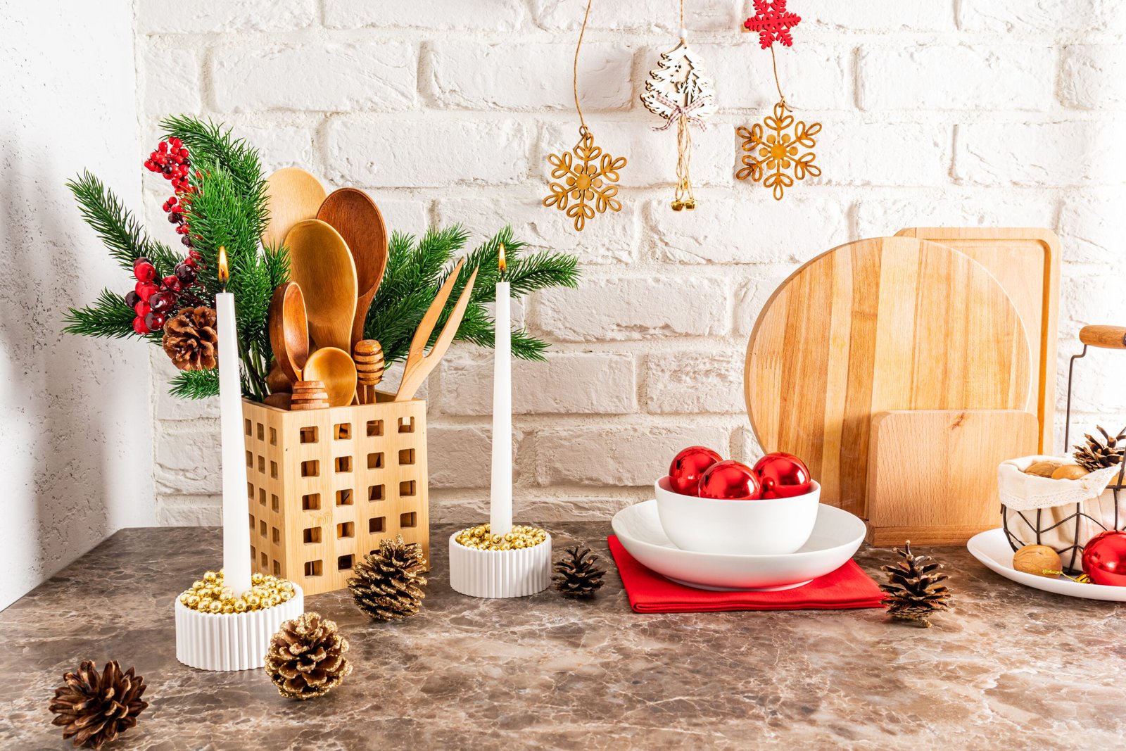 a fragment of a kitchen countertop decorated for the new year and Christmas. cozy interior of a modern kitchen. spruce branches, candles, balls.