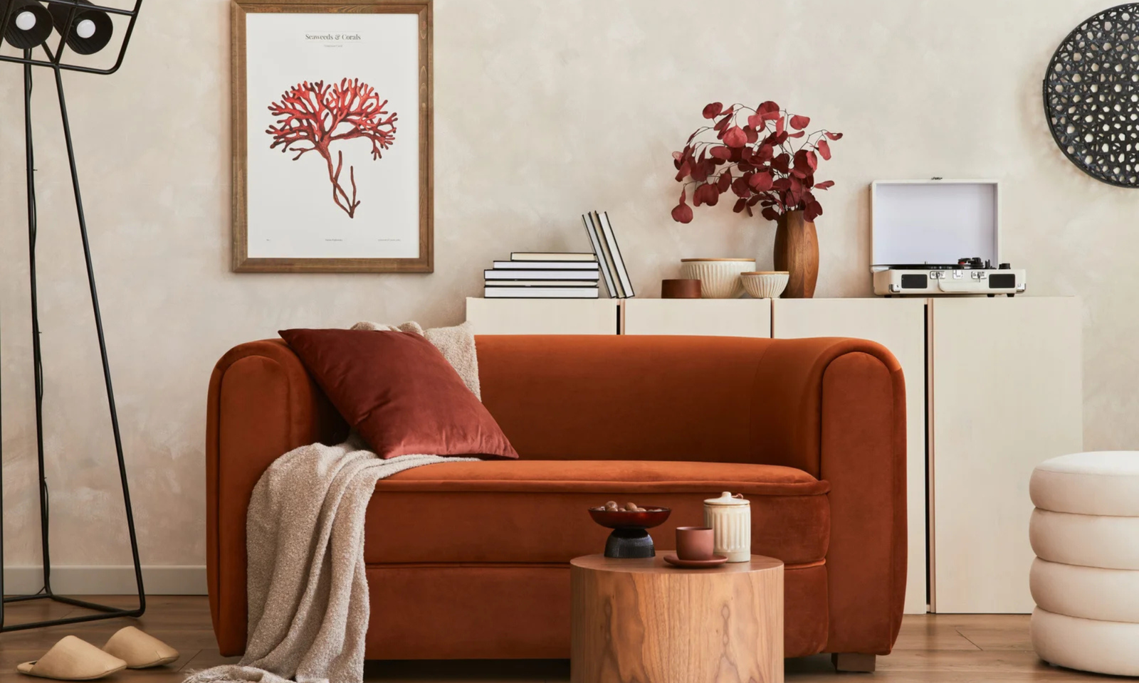 Stylish interior of modern living room with retro design sofa, mock up poster frame, pouf and creative personal accessories.