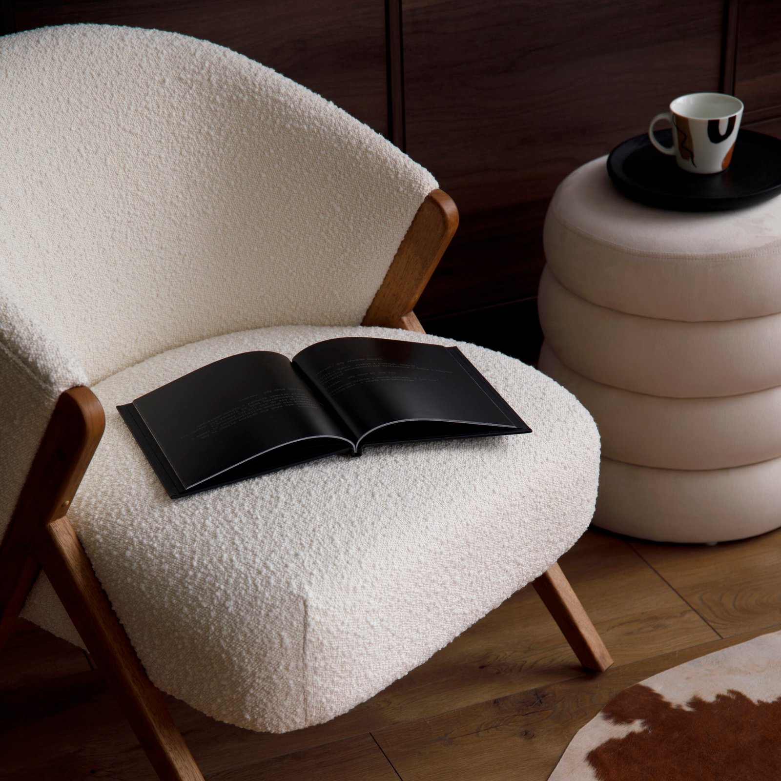 Elegant modern living room interior design with fluffy armchair, pouf, wooden commode, eco leather carpet and modern home accessories. Blue wall. 