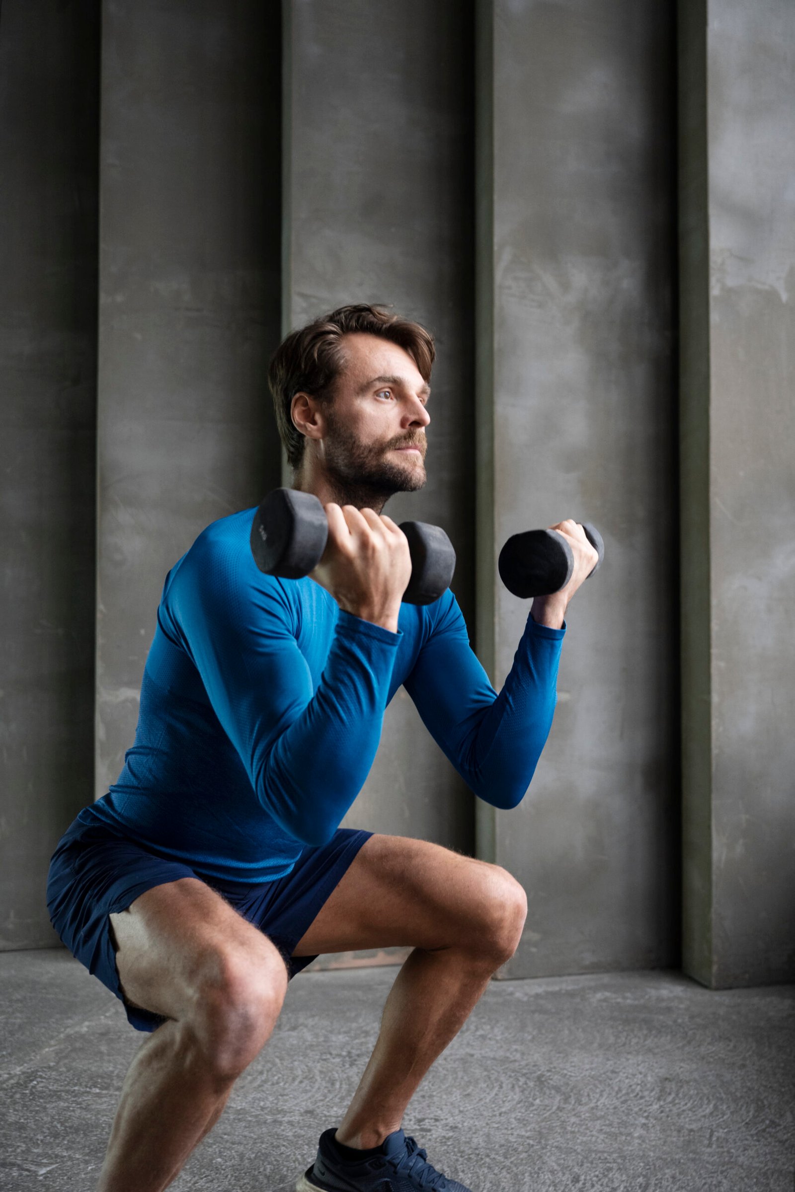 Full shot of man training with dumbbells. 