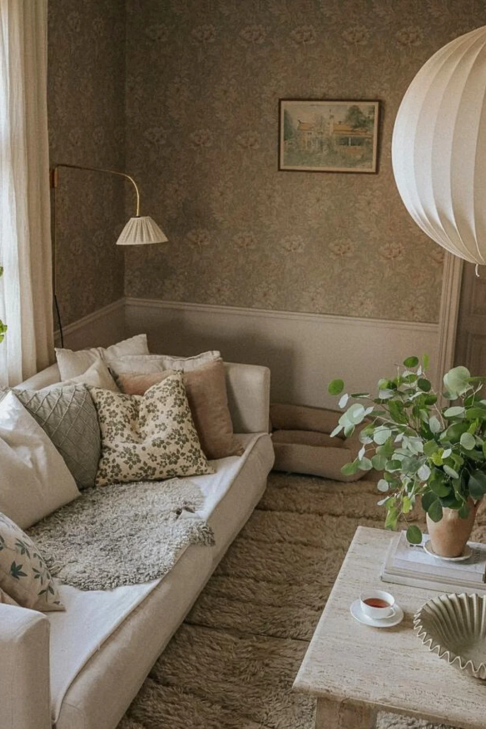 Swedish farmhouse living room with a bright sofa and a floor lamp. Wood panels on the wall. 