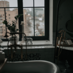 luxury interior bathroom with a large bathtub and natural light. Lots of plants.