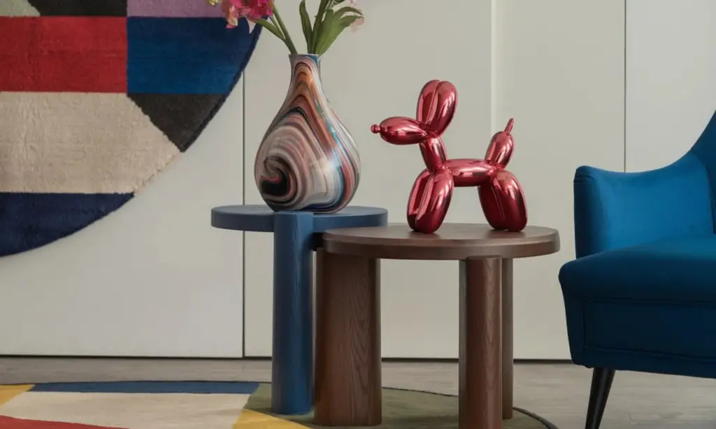 Colorful table with a vase with flowers in it, a red decorative dog and a blue accent chair.