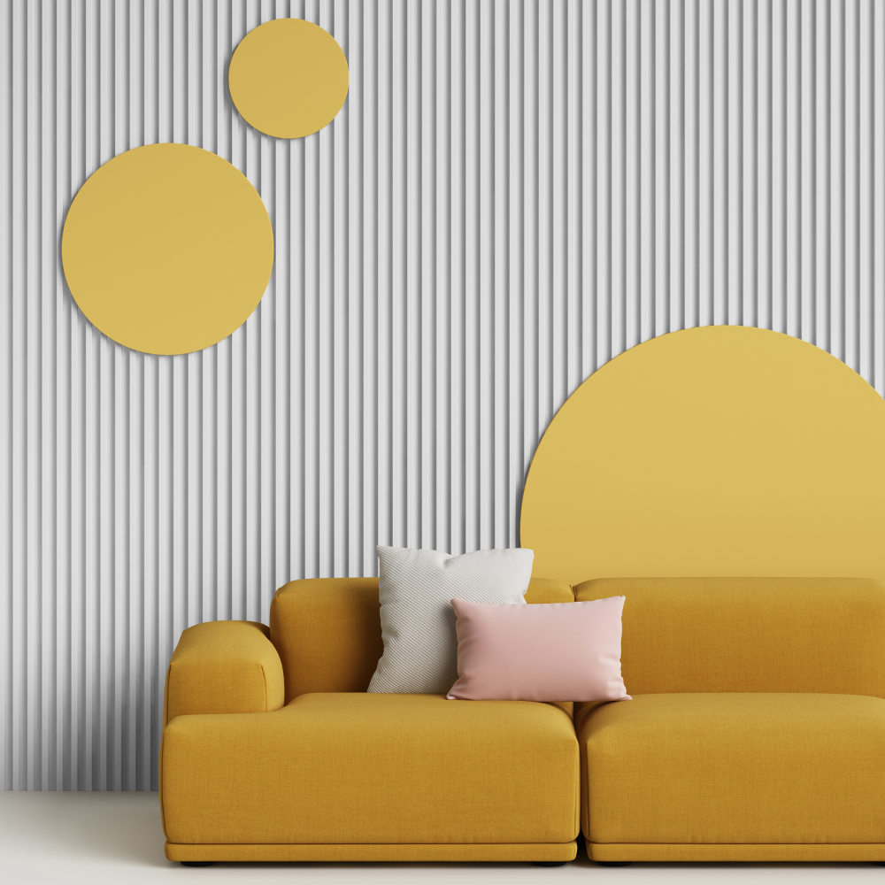 A yellow sofa with neutral colored pillows. A panel wall with round yellow decorations on it. 