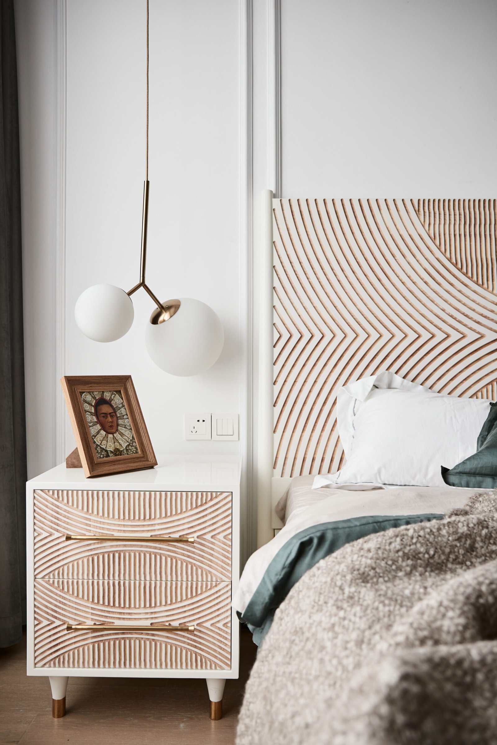 Bed with striped headboard and bedside table. Scaled. 