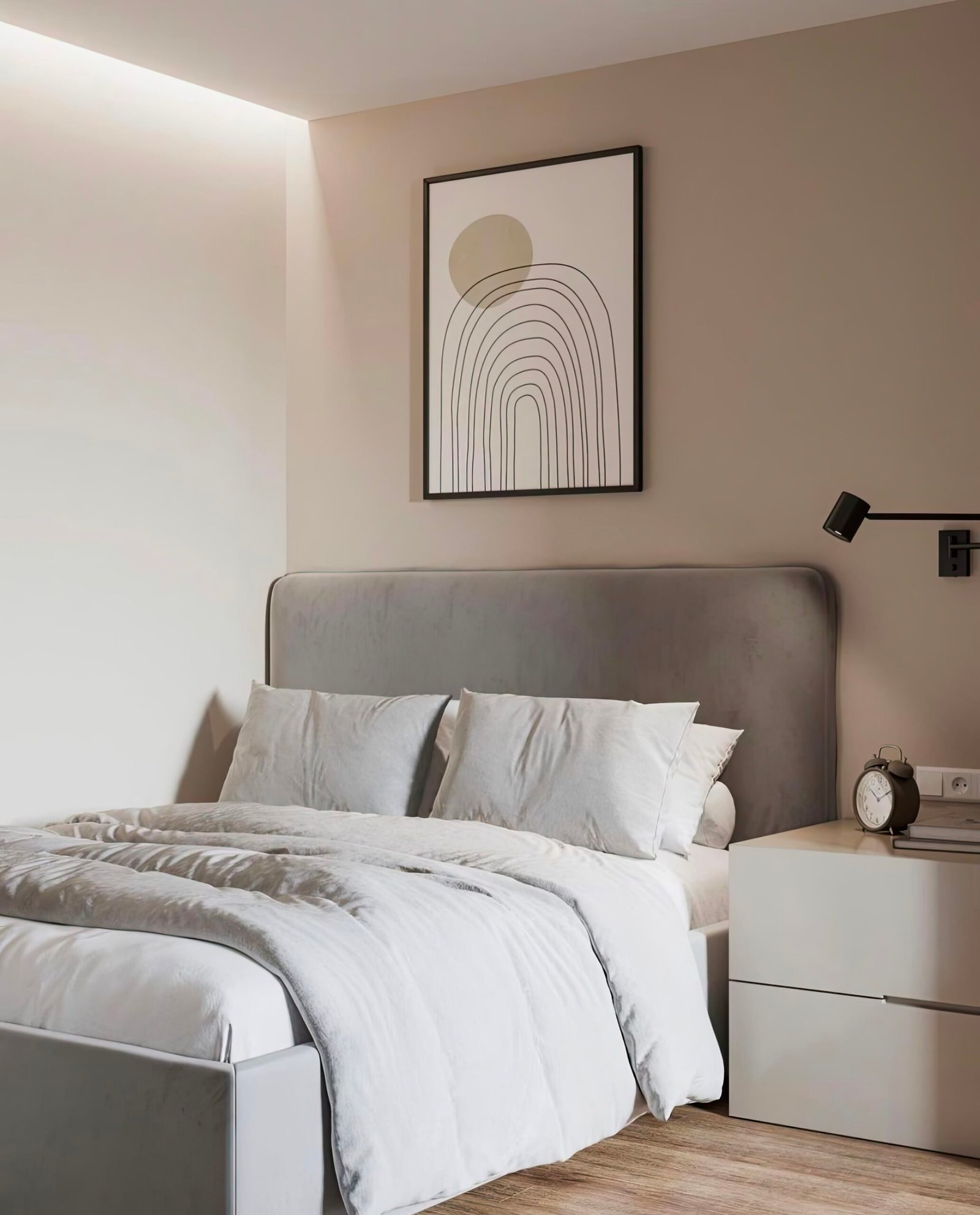 Framed picture above the bed. A grey bed with neutral bedding, a white bedside table and a black bedside lamp.