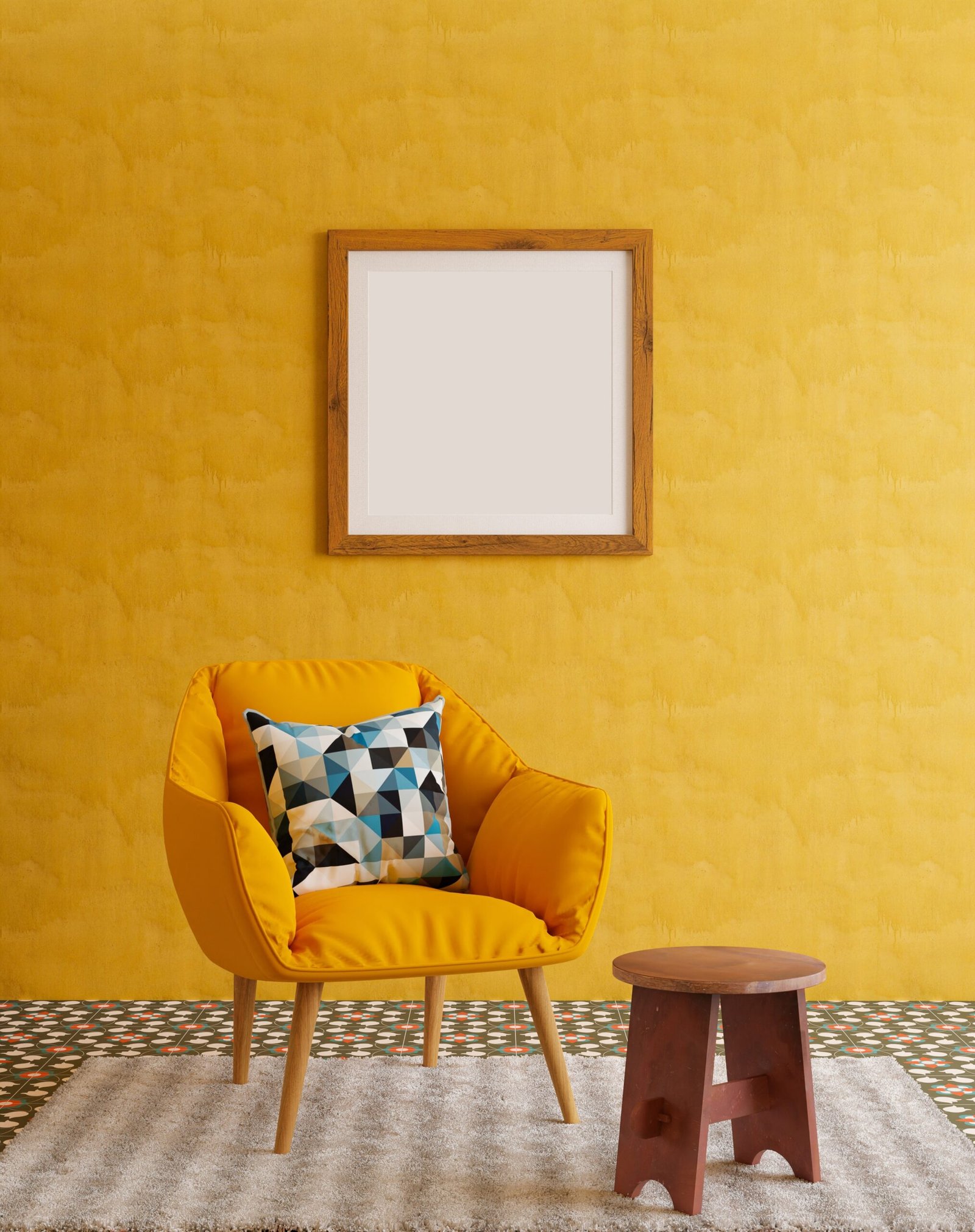 Empty wooden frame on a yellow wall, next to a yellow chair with a patterned pillow. A wooden stool. 