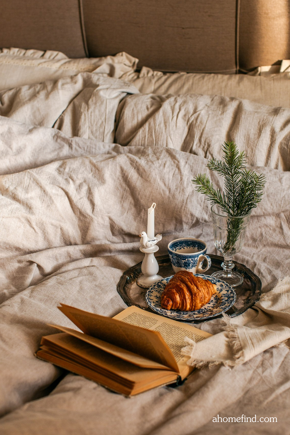 Neutral linen bed sheets styled with minimalist decor – perfect for a Japandi bedroom.