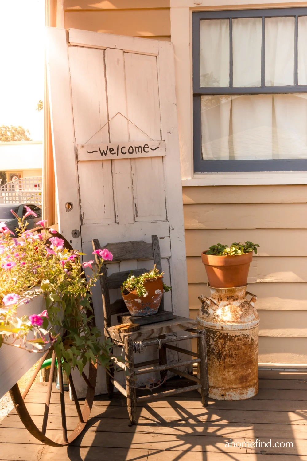 Farmhouse spring porch decor with Floral front porch arrangements and a wicker chair. 