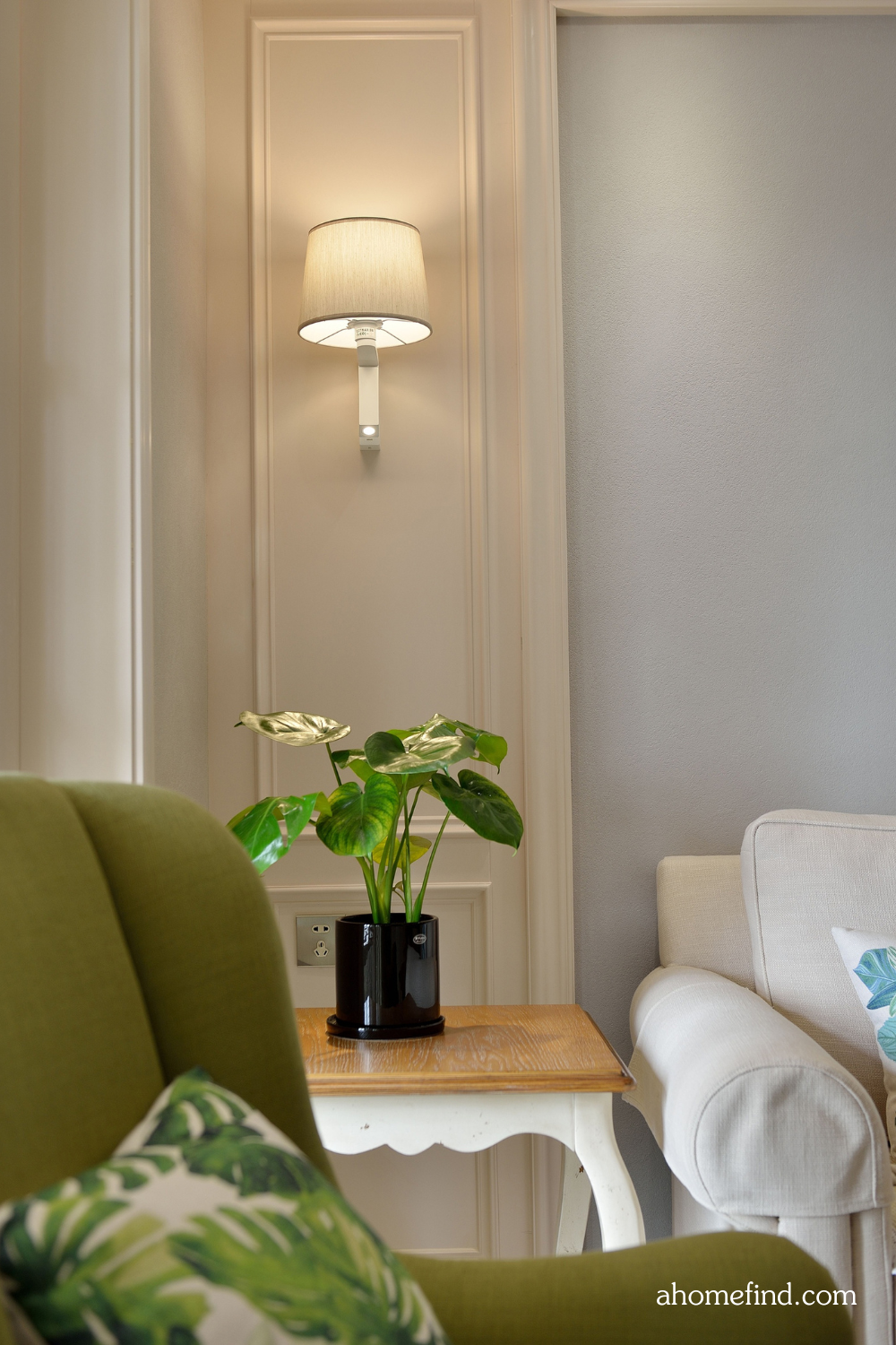 Closeup on a green couch and a wall lamp. Best lighting for living room. 