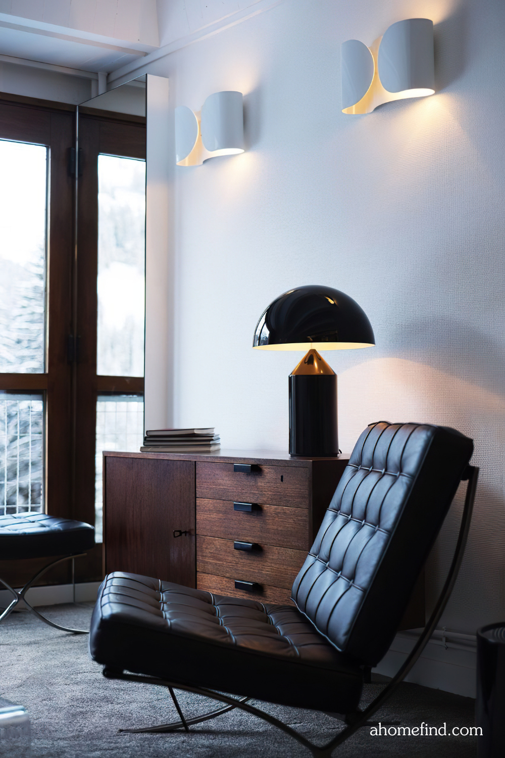 Best lighting for living room and Warm vs cool light. A black leather armchair and a sideboard with a lighting above. 