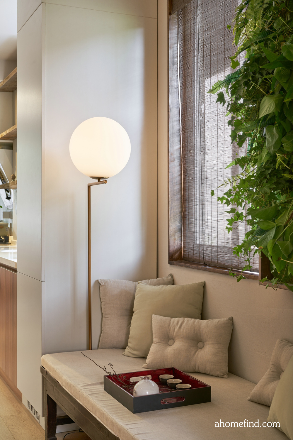 best light temperature for home. A cozy seating area in front of a window and a floor lamp and a plant. 