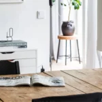 wabi sabi interior design with a rustic dining table, rustic pottery and decorative items.