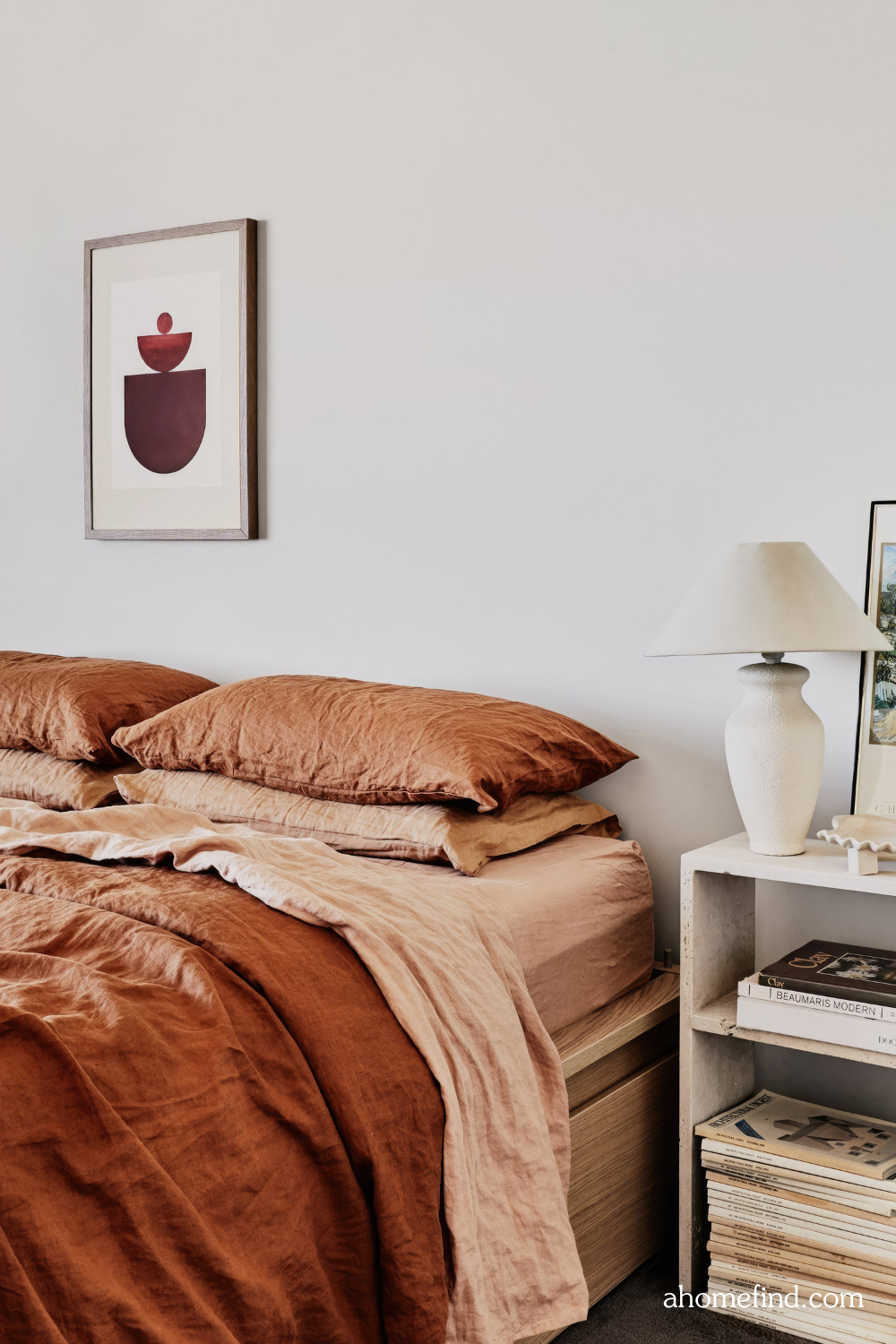 How to arrange furniture in a small bedroom. Rust bedding and a bedside table with a table lamp. Scaled. 