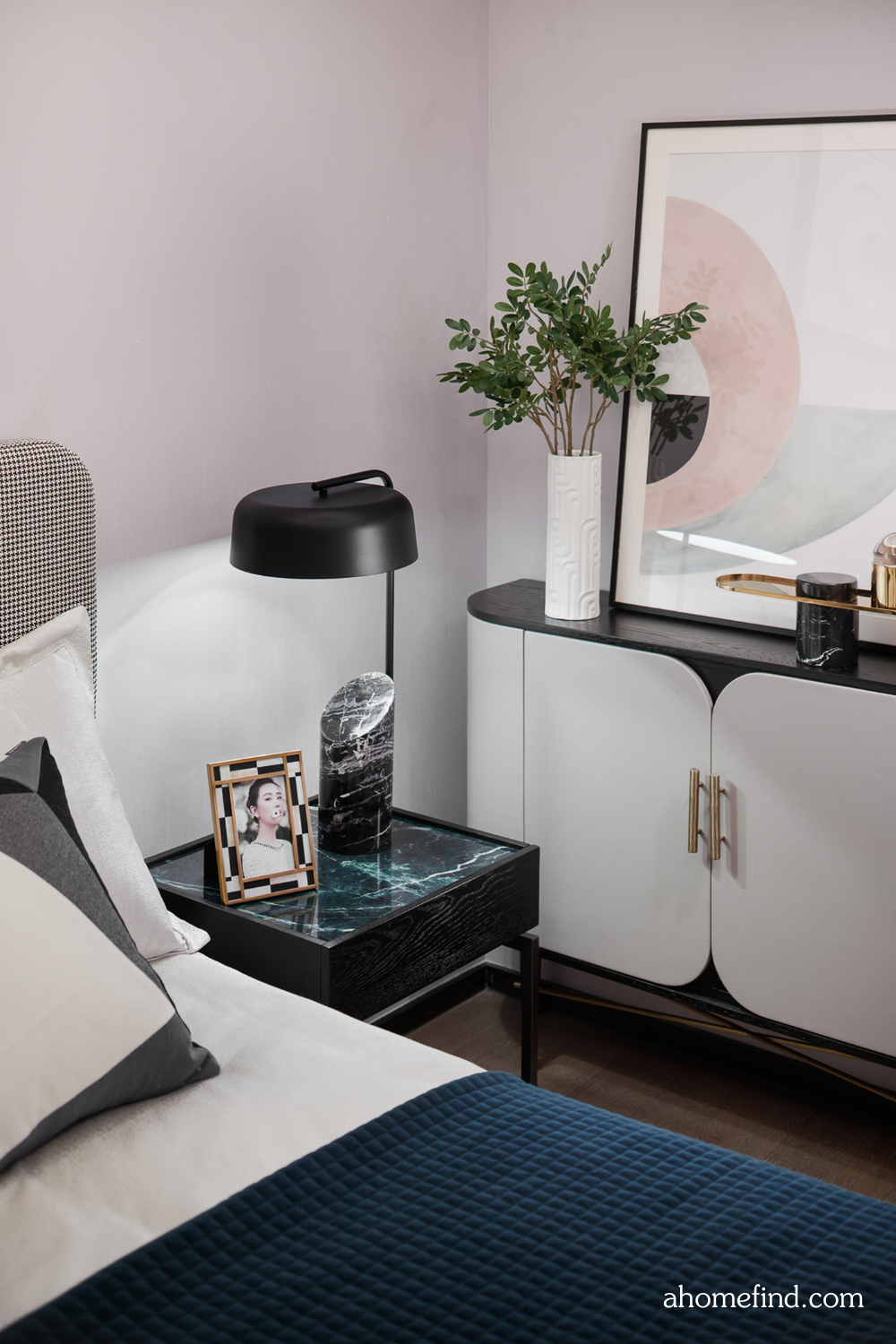 How to arrange a small bedroom with a marble bedside table and a black and white sideboard with decorations on it. 