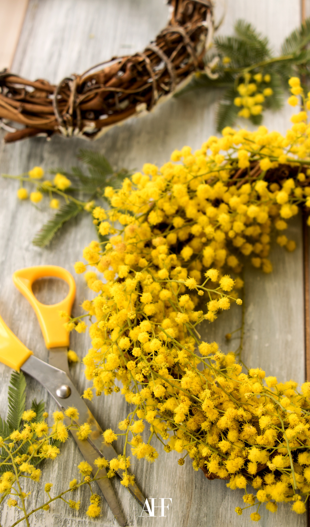 Midsummer wreath with yellow flowers in it on a table. Midsummer table setting ideas.