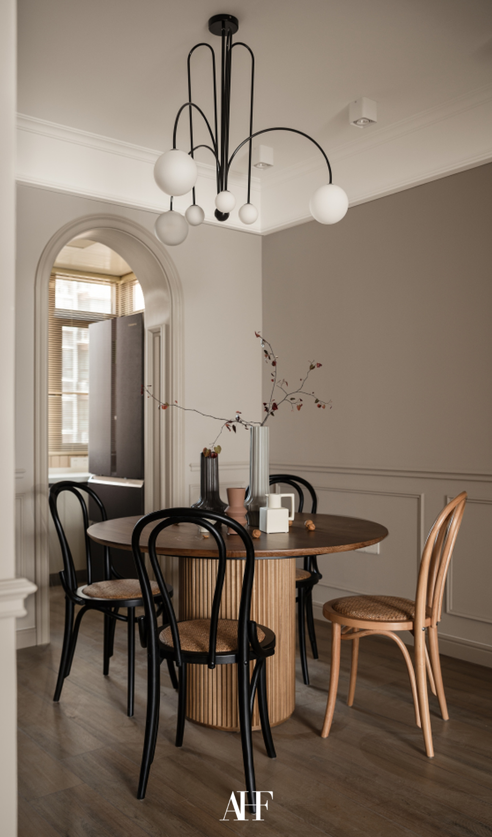 A dining room with a round dining table and round chairs. A minimalist dining room.