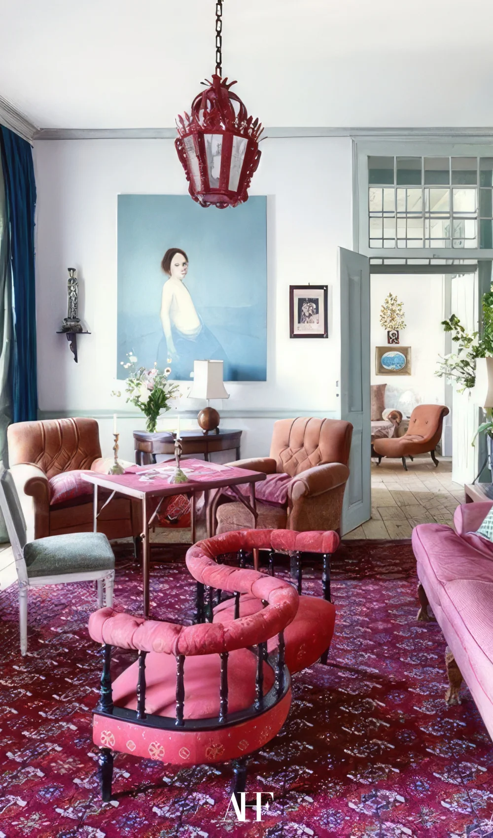 A bautiful maximalist interior design living room with a pink rug and pink chairs. Bold interior design and layering patterns and textures.