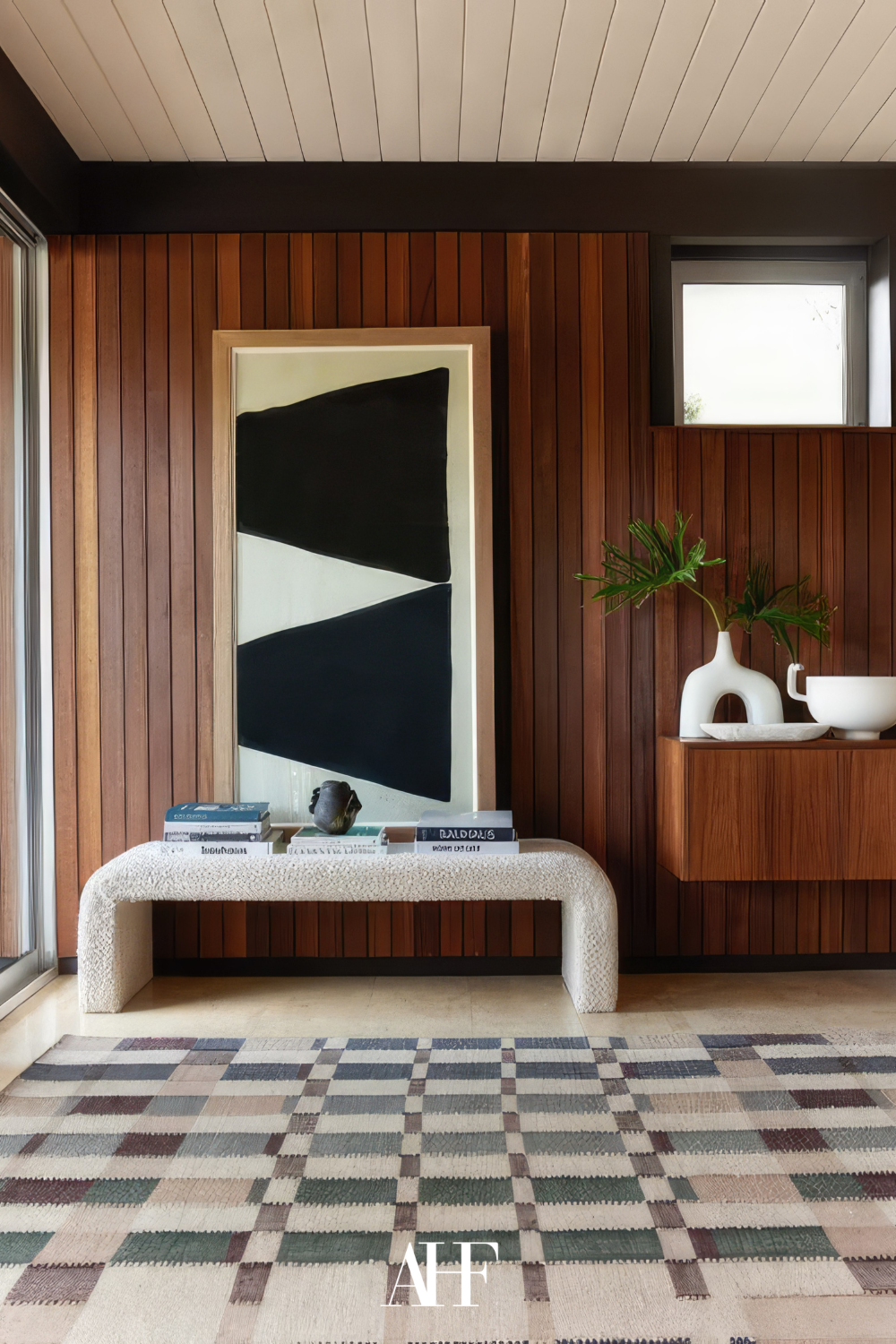 mid century modern interior with geometric shapes and wooden details. A bench and a sideboard. A rug. Scaled.