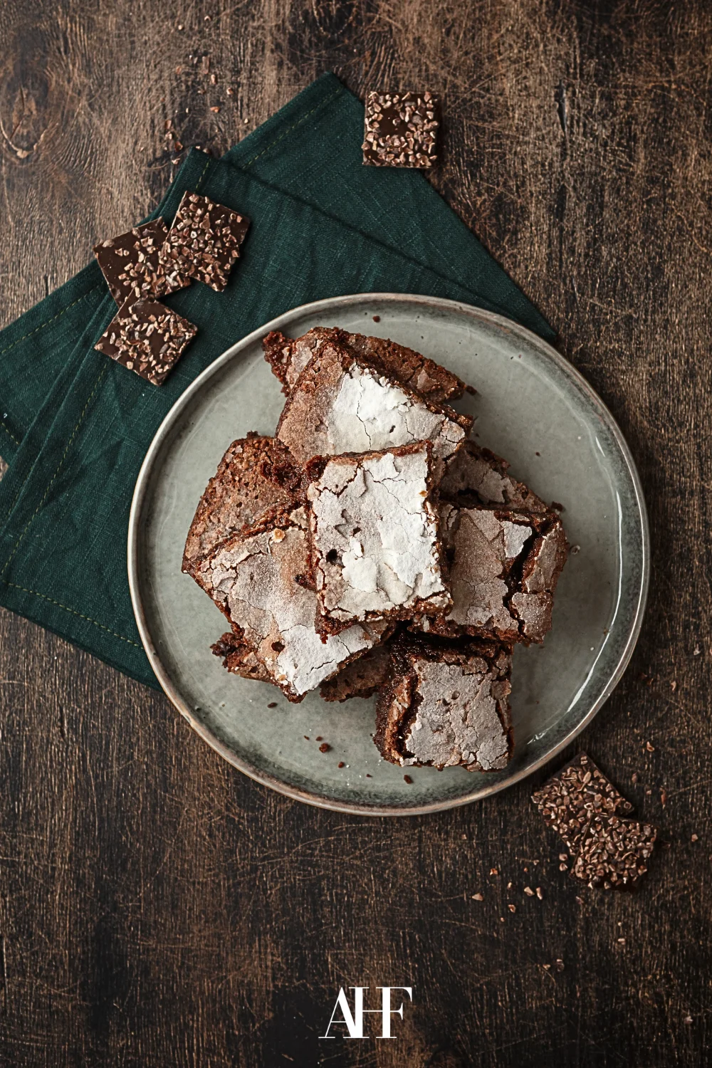 A rustic dessert plate with brownies on a wooden table.