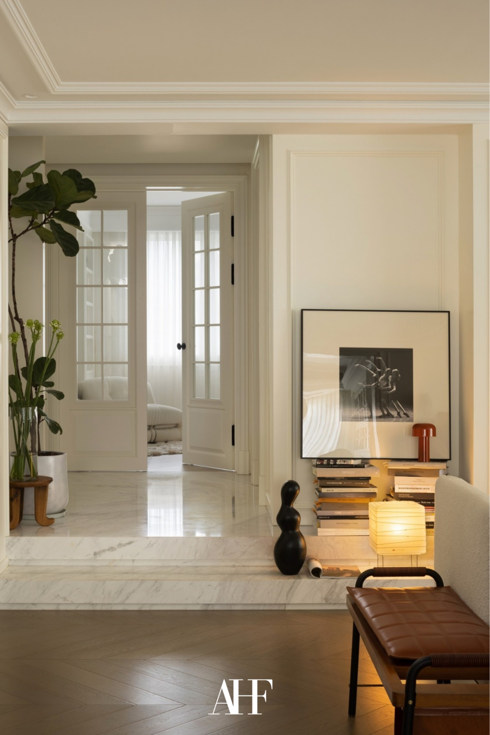 Interior design styles and a light color palette, large glass doors and a large wall art. A plant.