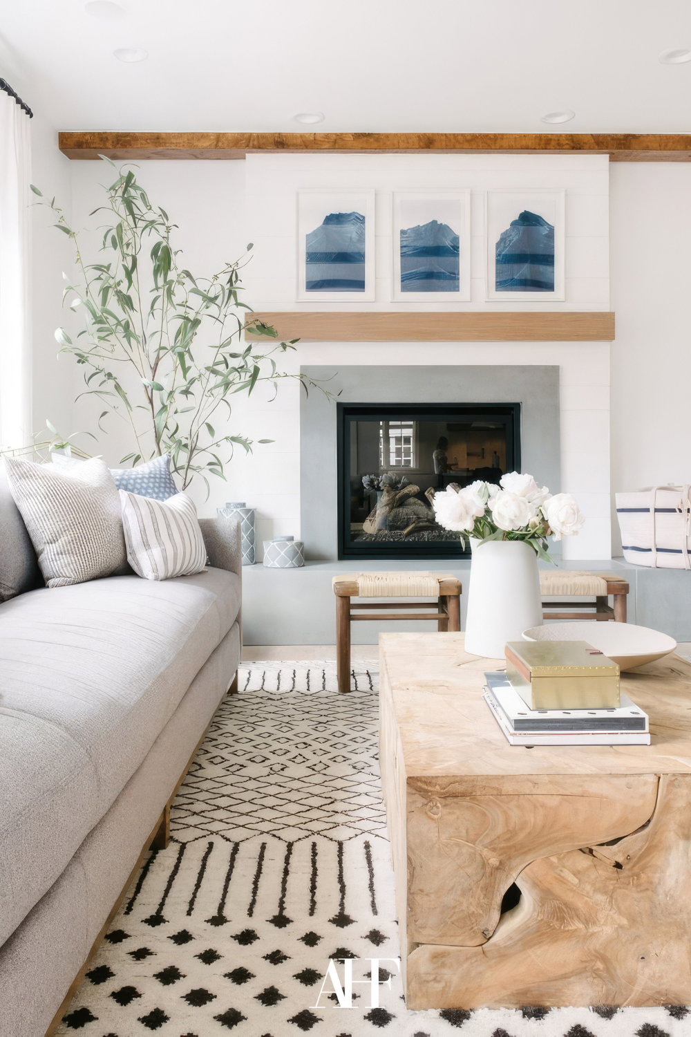 coastal design living room with a light foundation and blue details. A fireplace, a sofa and a coffee table. Scaled. Coastal living room design.