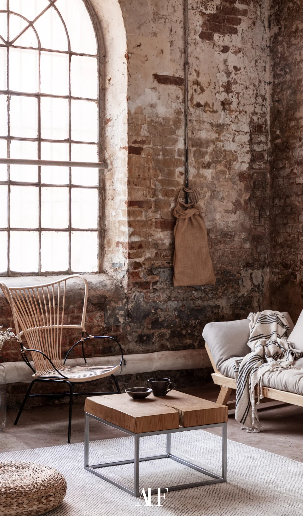 A industrial interior design living room with a brick wall, a sofa and a wooden chair. Cozy and stylish.